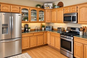A kitchen with wooden cabinets, stainless steel appliances, and a built-in microwave.