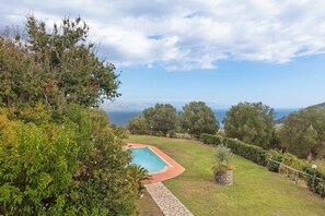 A swimming pool surrounded by lush greenery and a view of the sea. - Villa "Casale del Belvedere" with sea view, private pool and Wi-Fi (San Giovanni a Piro)