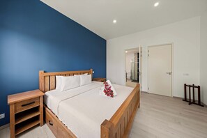 A bedroom with a wooden bed, a nightstand, a bedside table, and a white wall. - Cliffside Oasis-The Villa Private gym/pool-Seaview (Sint Michiel)