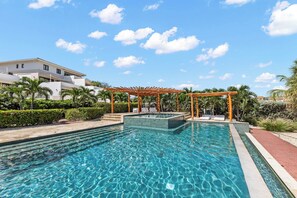 A clear blue pool with a wooden pergola and lounge chairs, surrounded by greenery and a white building. - Casa Quince - Greenview - Sea View Retreat (Sint Michiel)