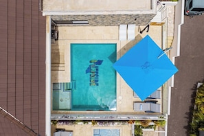 A rooftop pool with a clear view of the sky, surrounded by a stone wall and a metal railing. - Cliffside Penthouse - Private Pool - Seaview - Bluebay (Sint Michiel)