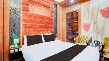 Une chambre d’hôtel avec un grand lit, une table de chevet, une lampe, une chaise et un mur décoratif.