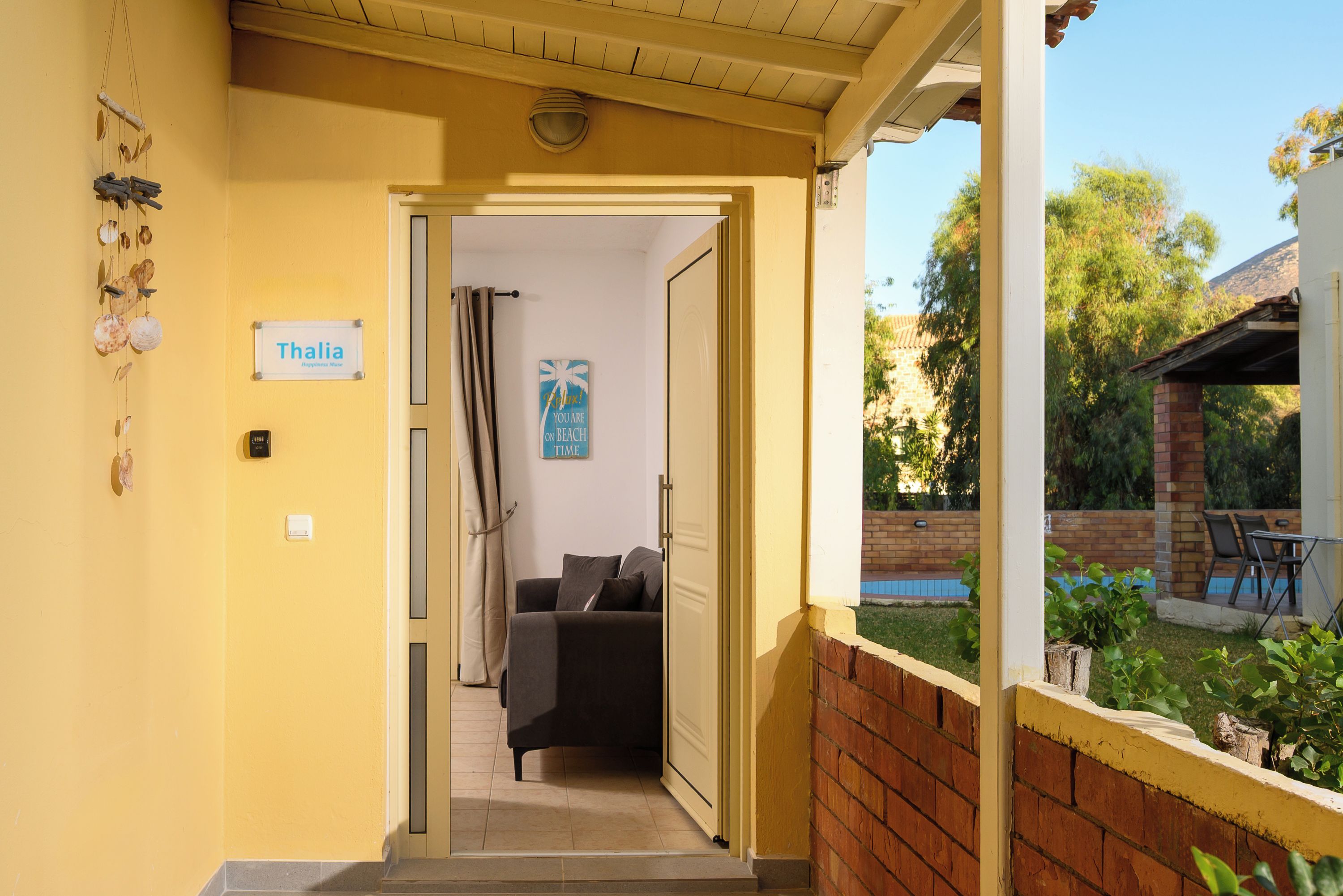 A hallway leading to a room with a bed and a sign that reads 'Thalia'.