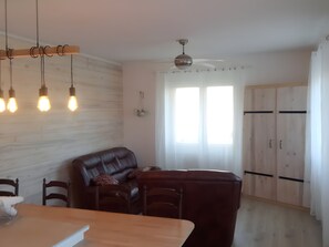 Eine moderne Küche mit Essbereich, Holzschränken und Deckenventilator.