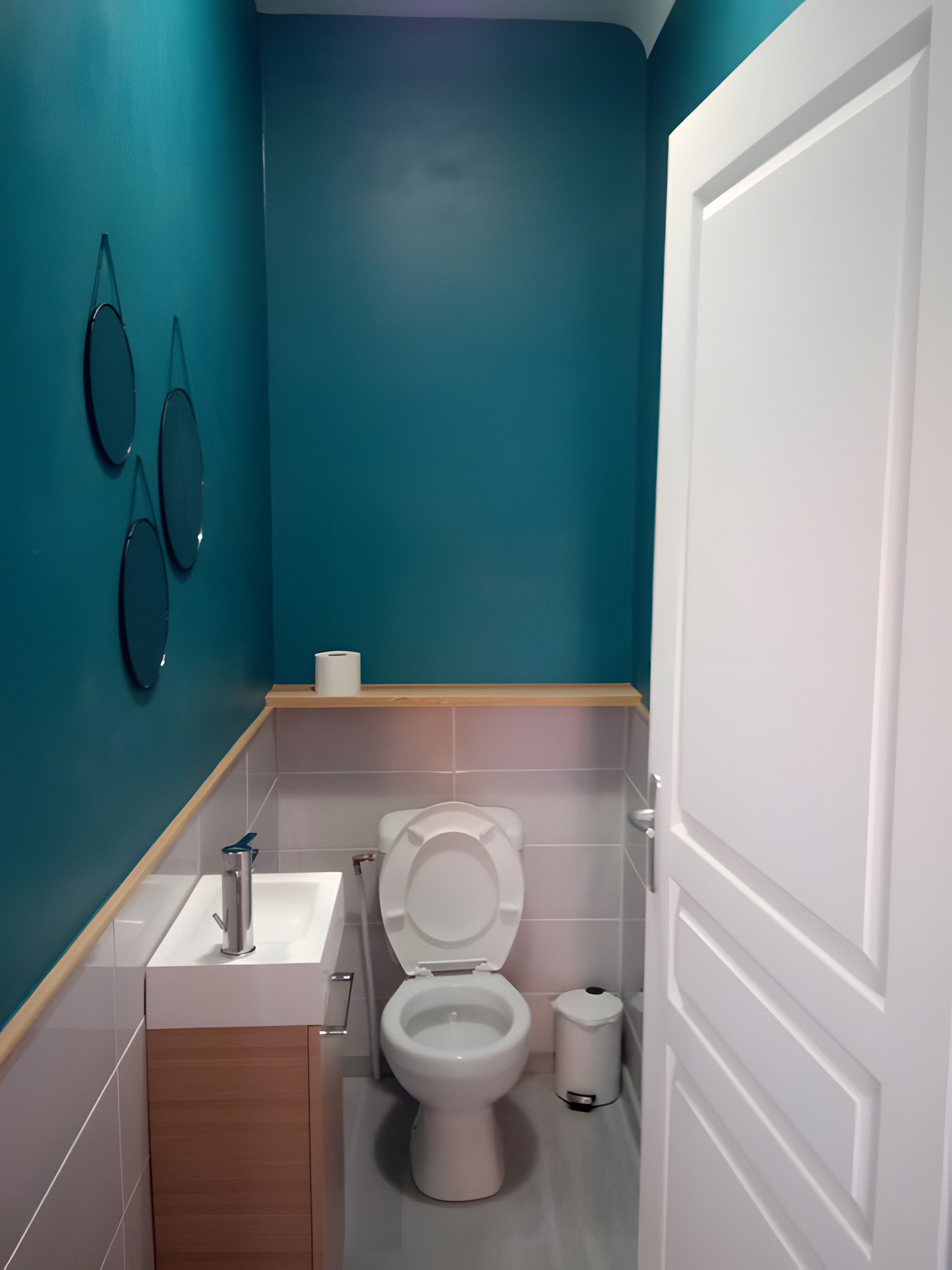 Un bagno con il water, lavandino e specchio.