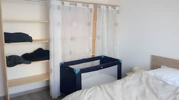 Un dormitorio con una litera, una mesita de noche y un armario.
