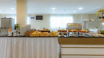 A buffet setup with various food items and a coffee station.