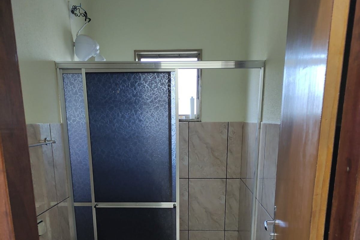 Een kleine badkamer met toilet, wastafel en douchegedeelte.