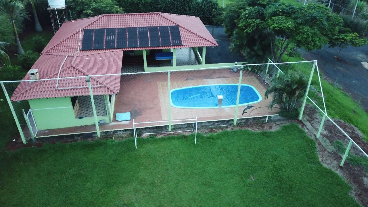 Una propiedad residencial con piscina, un patio cubierto y un patio cercado.