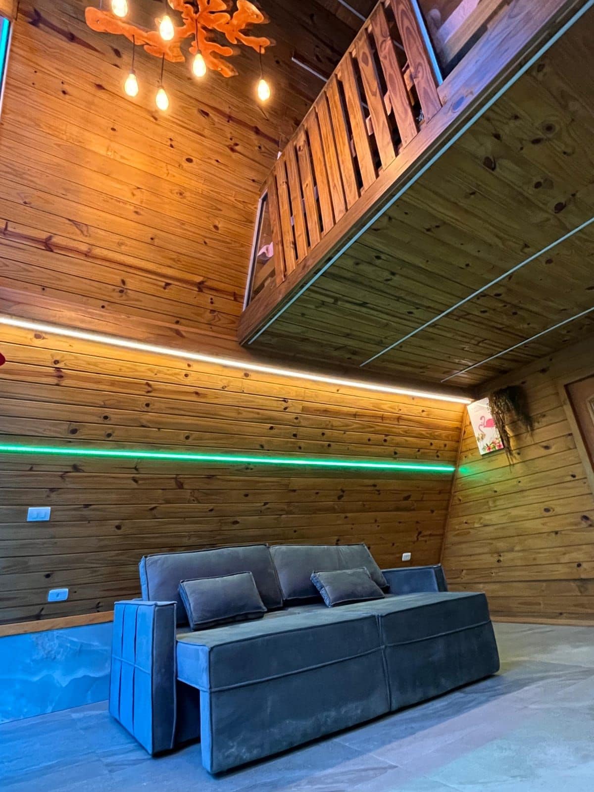 Un interior de madera con un sofá y una lámpara en el techo.