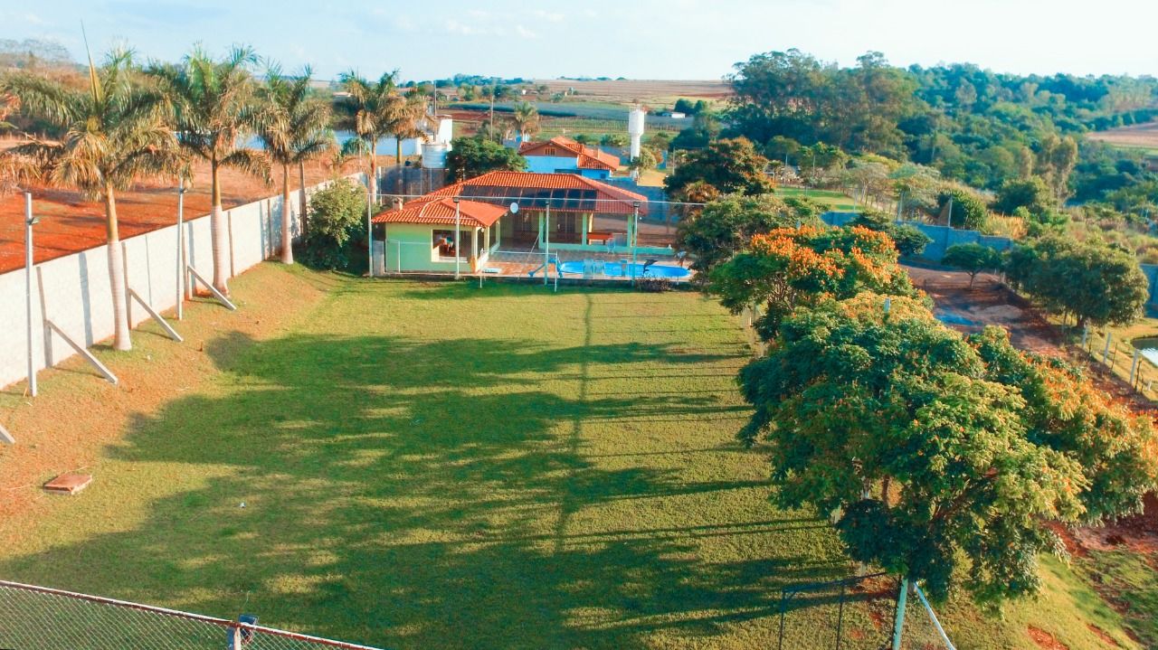 Un immobile residenziale con cortile recintato, piscina e una casa dal tetto rosso.