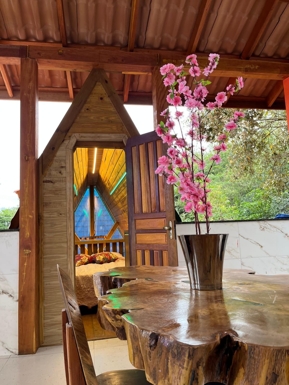 Estructura de madera con una puerta que da a una habitación con una cama y una ventana.