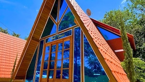 Un edificio de forma triangular con ventanas amplias y techo rojo.