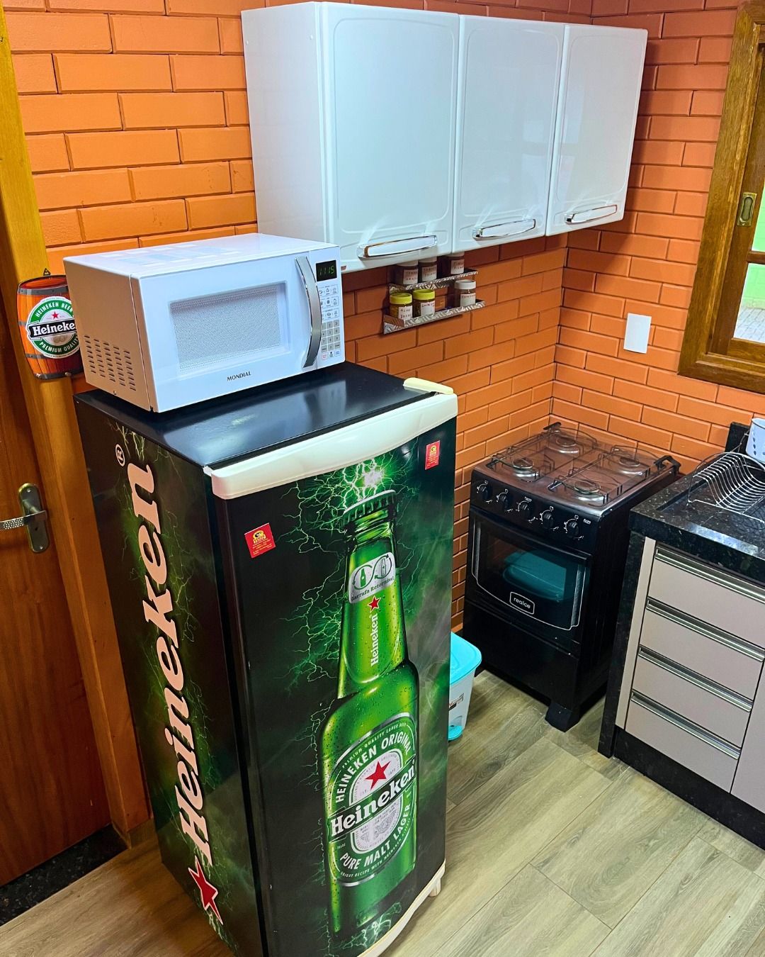 A kitchen with a refrigerator, microwave, stove, and cabinets.