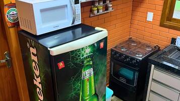 Una cocina equipada con refrigerador, microondas, estufa y armarios.