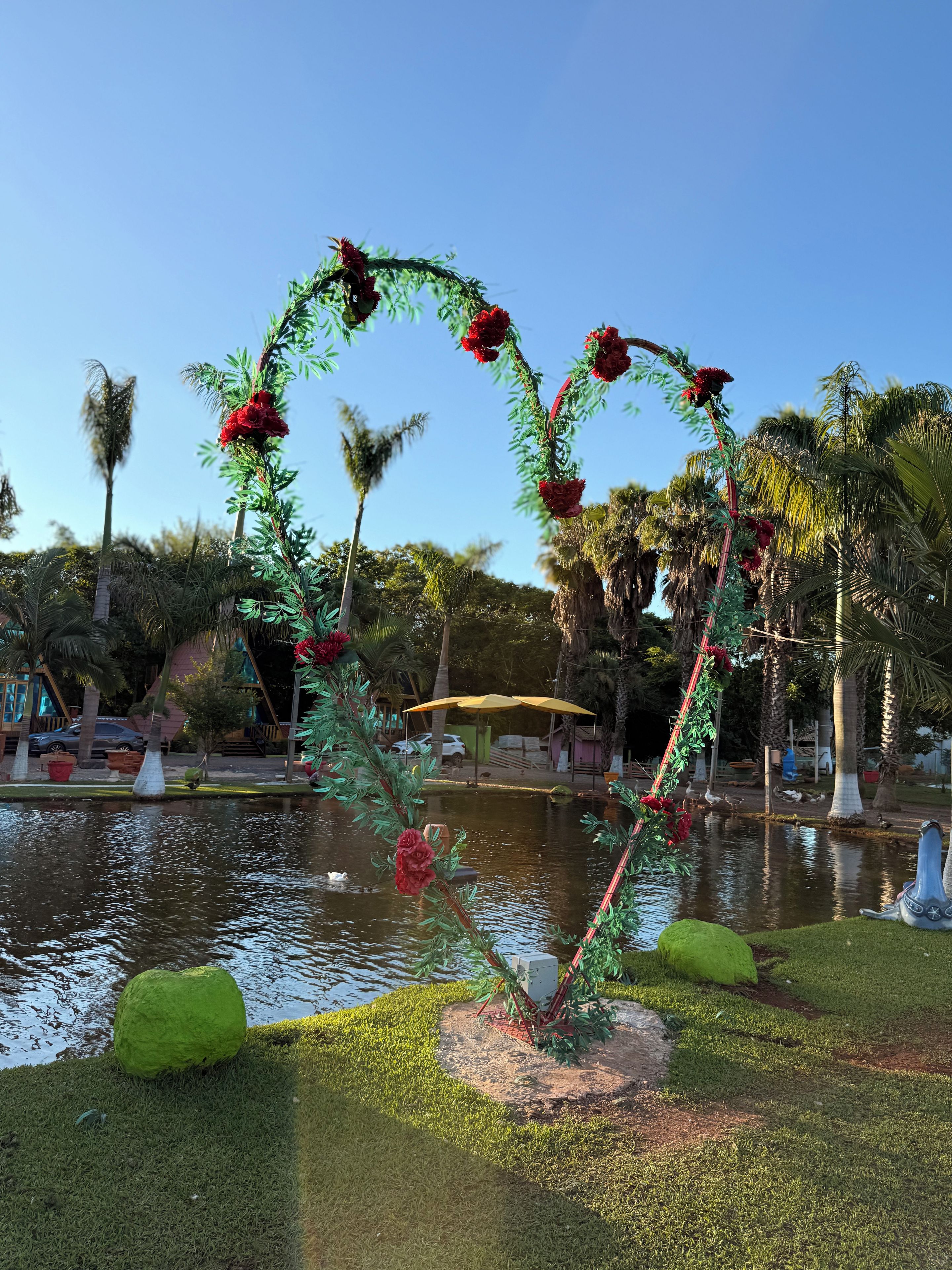 A heart-shaped floral arrangement with a water feature in a landscaped area.