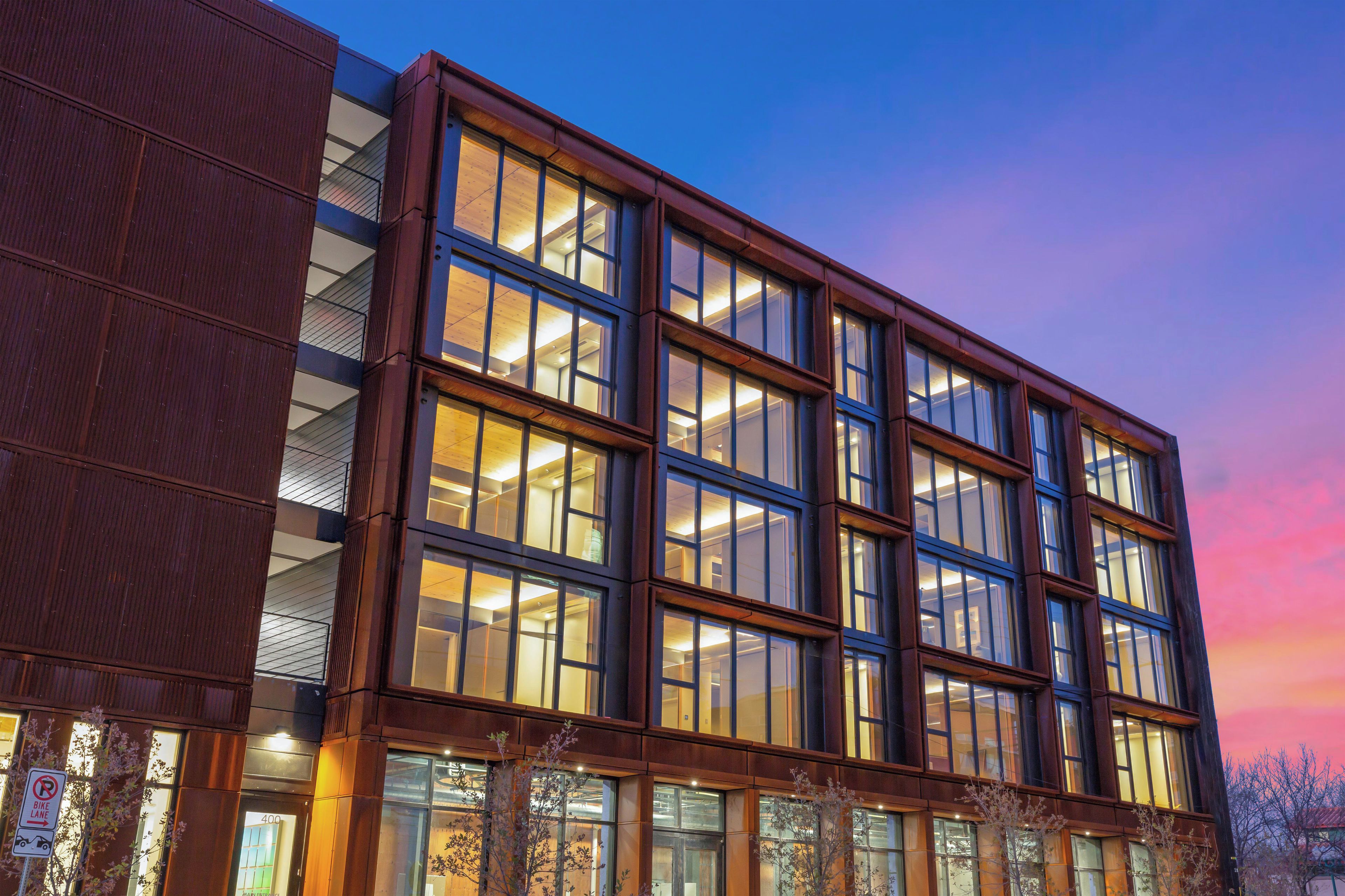 A modern building with multiple floors, large windows, and a mix of glass and metal exterior.