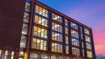 A modern building with multiple floors, large windows, and a mix of glass and metal exterior.