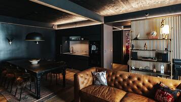 A modern interior with a leather sofa, dining table, and kitchen area.