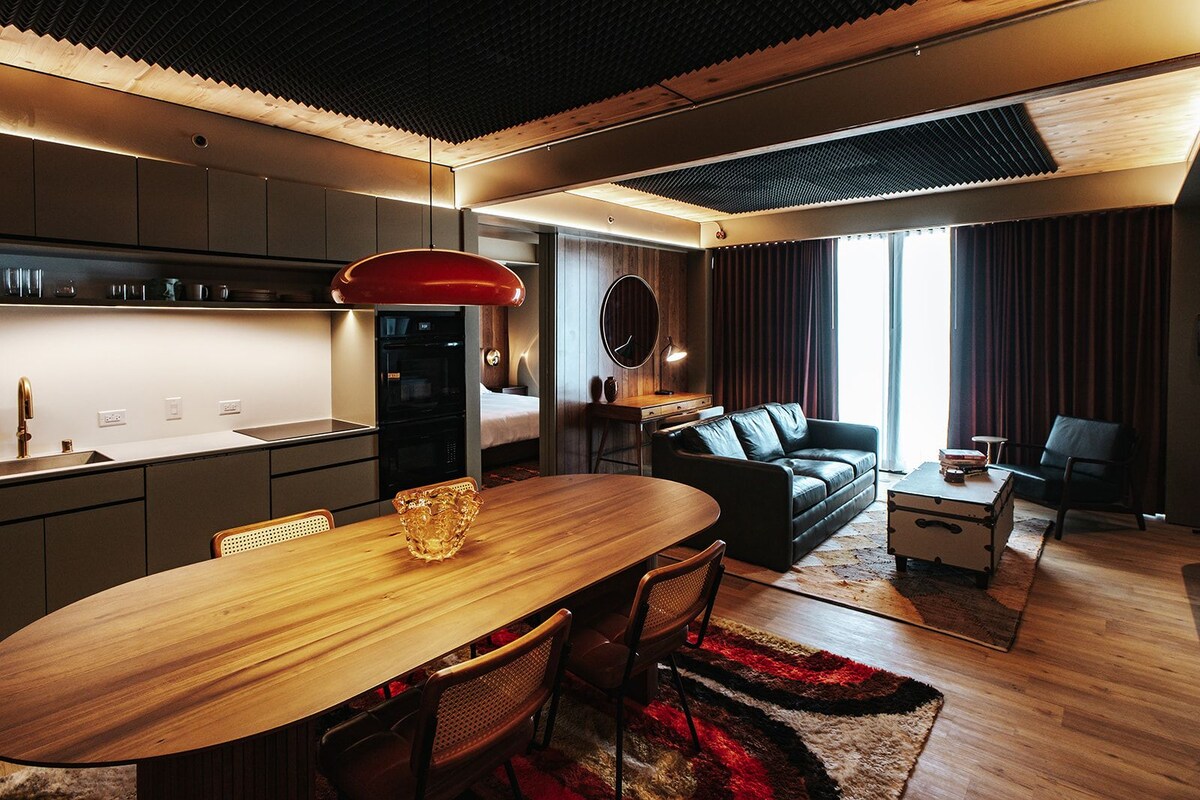 Una cocina moderna con zona de comedor, un sofá y una pequeña mesa con libros.