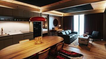A modern kitchen with a dining area, a sofa, and a small table with books.