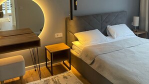 A modern bedroom with a bed, bedside table, and a mirror with a circular light. - Playwright Test Hotel 1789146053536 (Seattle)