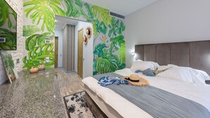 A modern bedroom with a large bed, a headboard, and a tropical leaf mural on the wall. - Playwright Test Hotel 1789146053536 (Seattle)