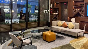A modern interior with a sofa, chairs, a coffee table, and hanging lights. - Playwright Test Hotel 1789146053536 (Seattle)