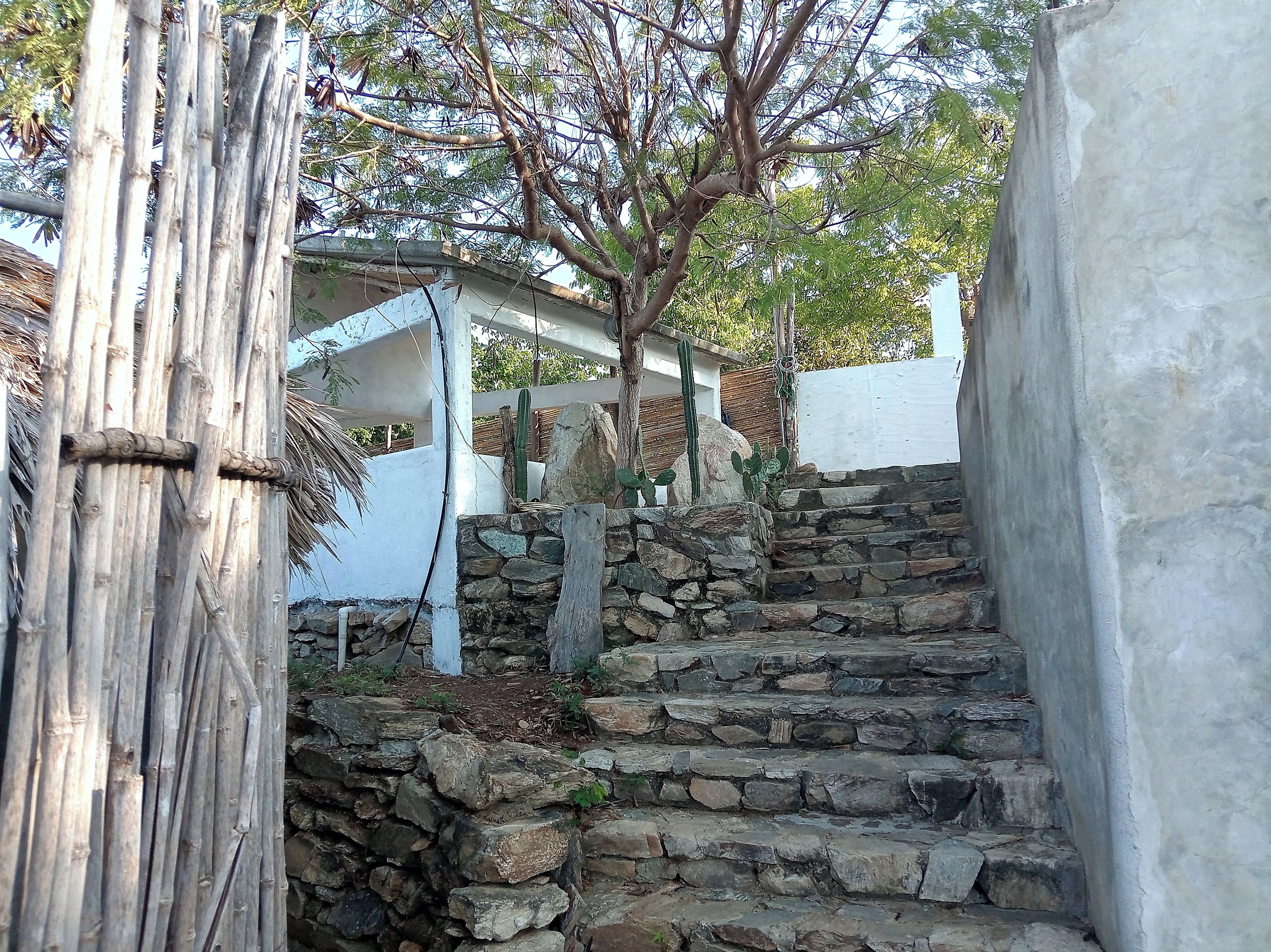 A stone staircase leading up to a white building with a wooden structure on the left.