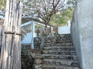 A stone staircase leading up to a white building with a wooden structure on the left.
