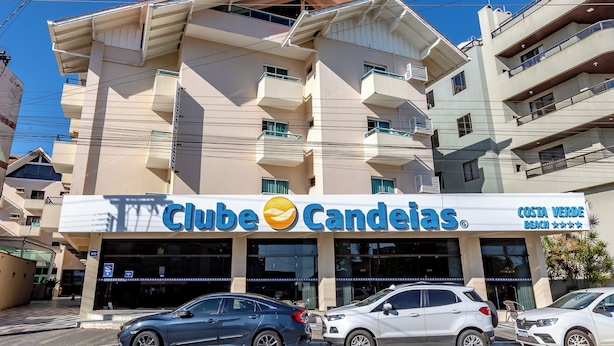 Ein Gebäude mit einem Schild, auf dem 'Clube Candeias' und 'Costa Verde Beach' stehen, was auf ein Hotel oder Resort hindeutet.