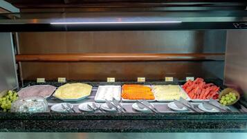 Un buffet proposant une variété de plats et d’ustensiles.