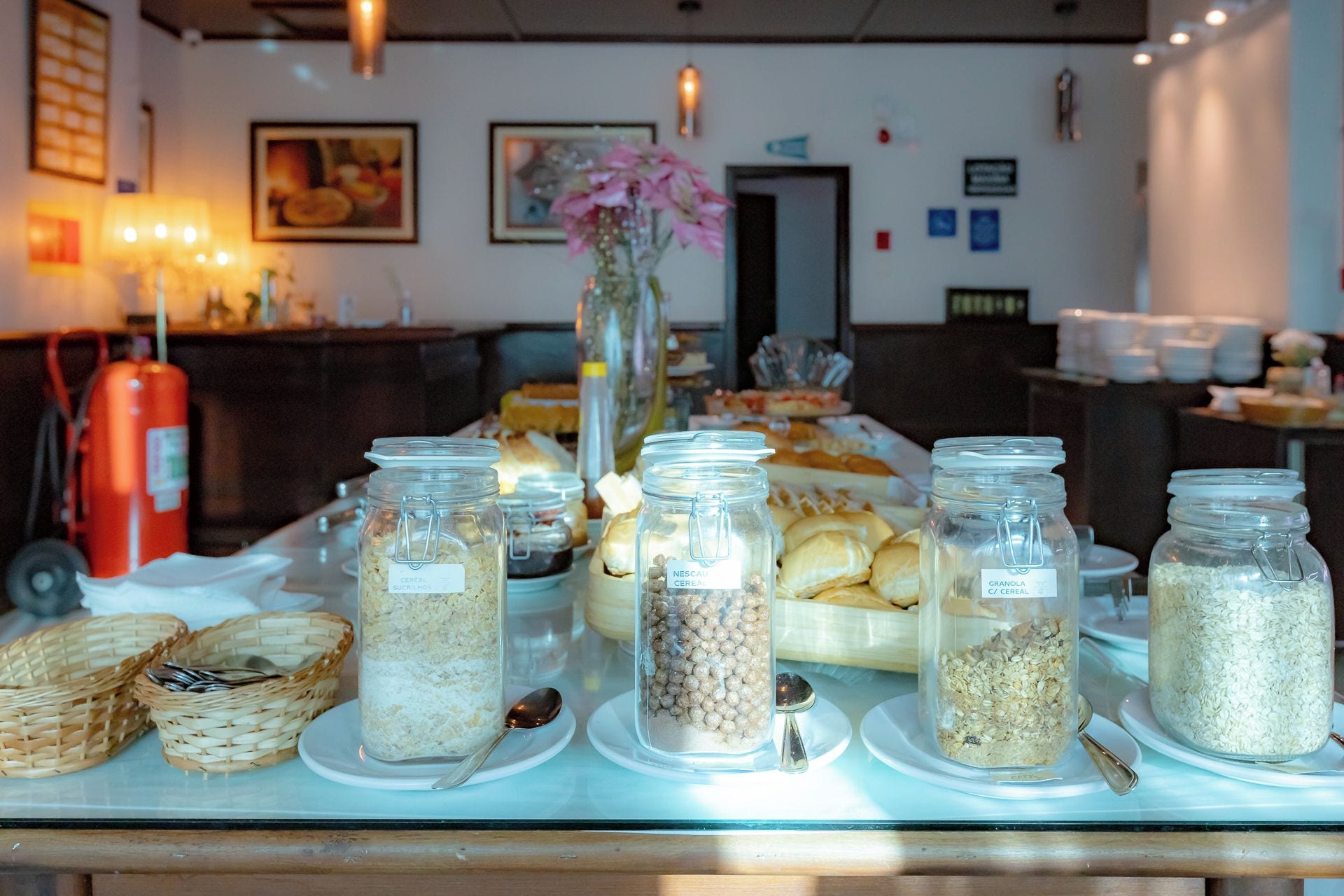 A buffet table with various food items and jars labeled with different types of cereal.