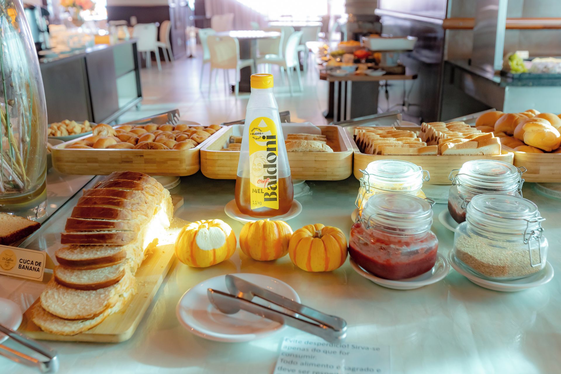 A buffet with various food items including bread, pastries, and condiments.
