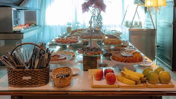 Une table de buffet proposant divers plats et une présentation de fruits.