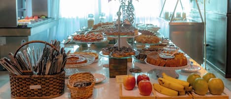 A buffet table with various food items and a fruit display.