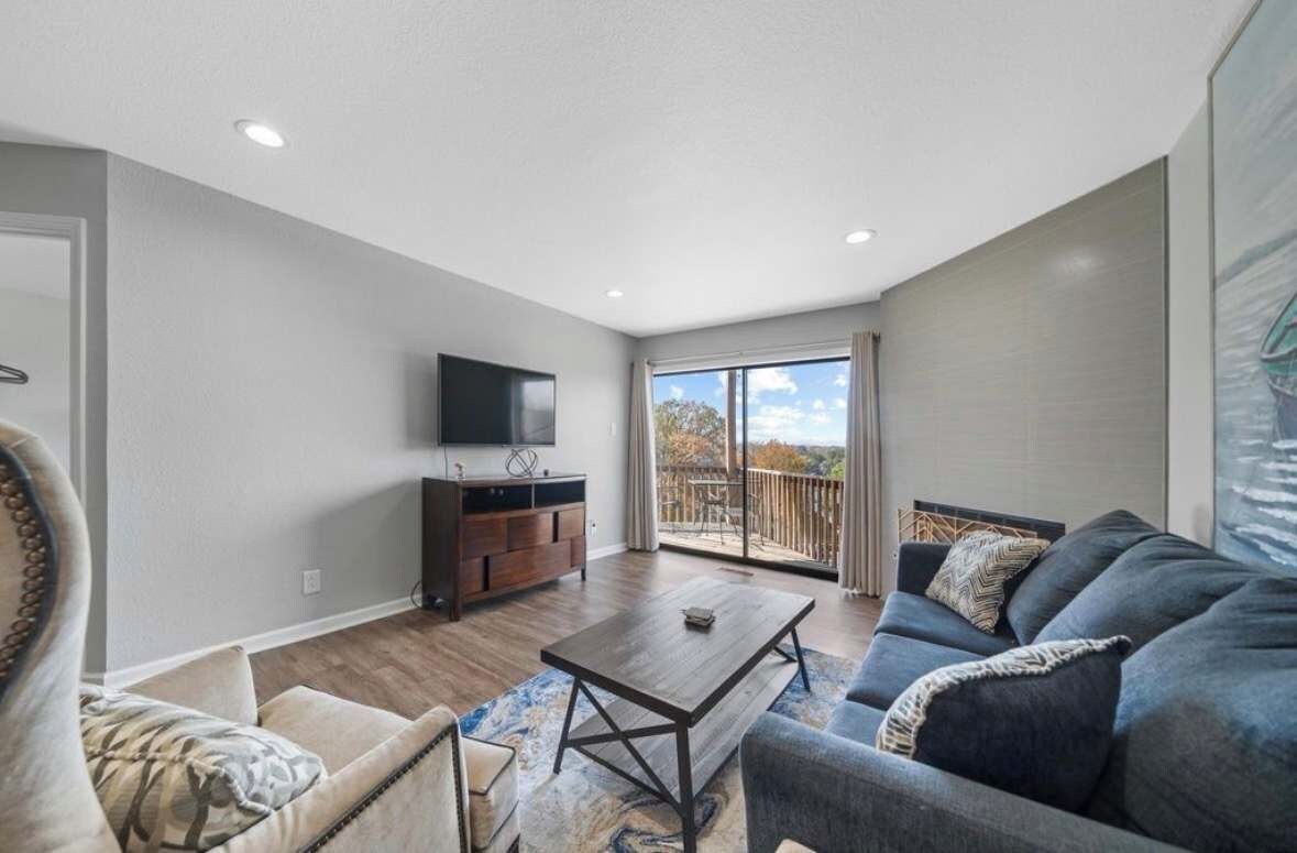 A spacious living room with a sofa, coffee table, and a flat-screen TV.