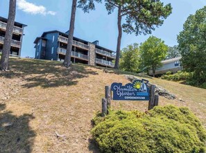 A sign for Hamilton Harbor Condominiums with a view of the building and surrounding trees. - Hamilton Harbor Hideaway | Lake Views & Pool (Hot Springs)