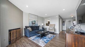A modern living room with a blue sofa, a coffee table, and a rug.