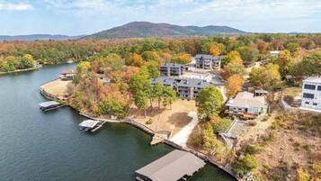 A lakeside property with multiple buildings, docks, and a docked boat.