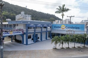 Een gebouw met een blauwe gevel en een bord met de tekst 'Clube Candeias'.