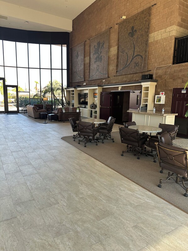 Eine geräumige Lobby mit einer Rezeption, einer Sitzecke und großen Fenstern.