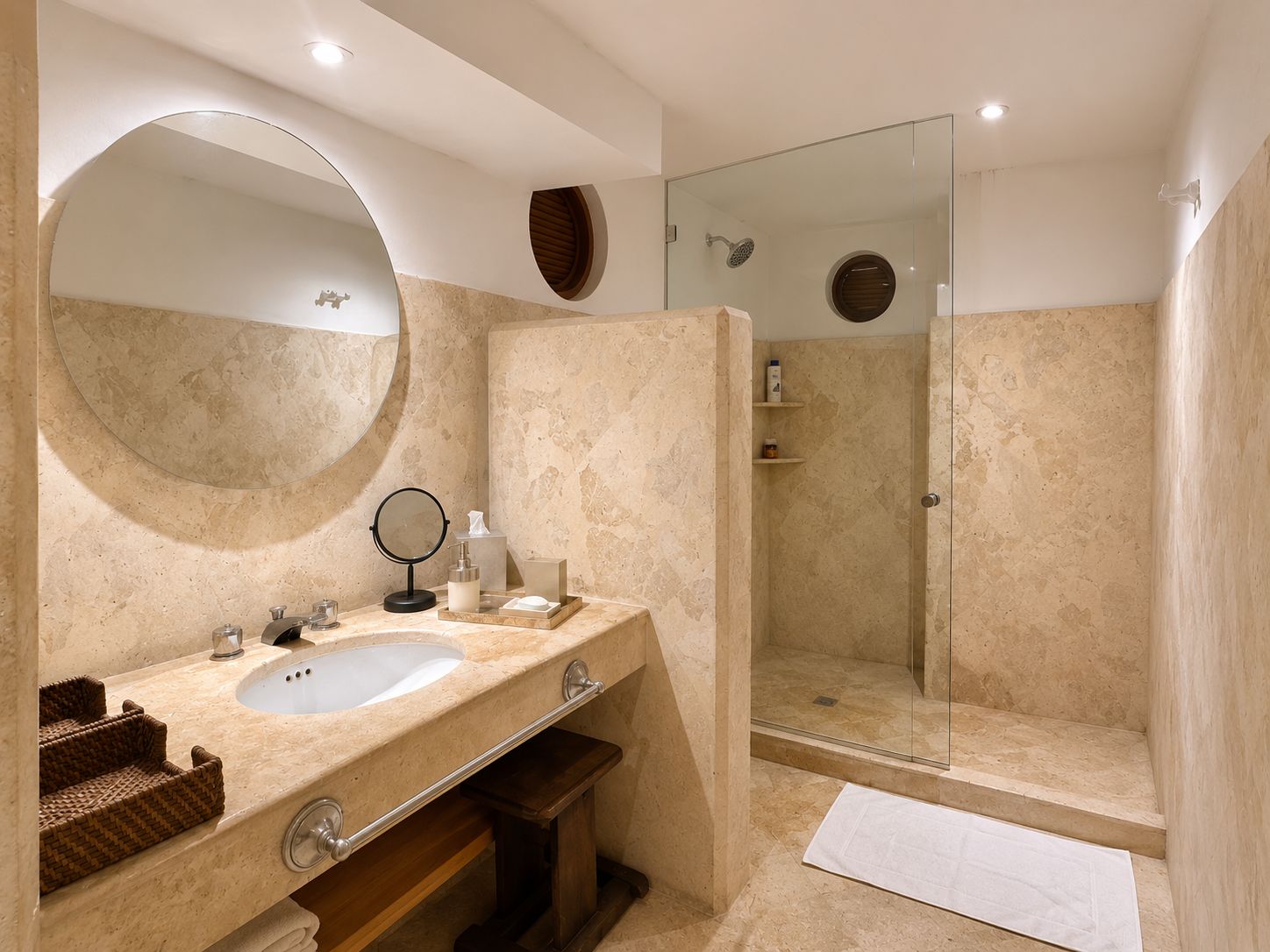 A bathroom with a large mirror, a sink, a shower, and a towel.