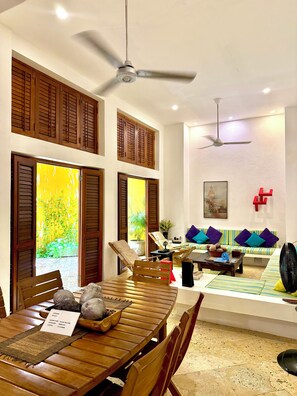 A dining area with a wooden table, chairs, and a ceiling fan. - Calamari Homes - El Porvenir 205 - Walled City (Cartagena de Indias)