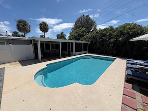 Ein rechteckiger Swimmingpool mit Fliesenrand, umgeben von einer Betonplattform.