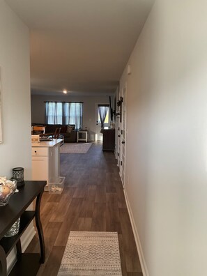 A hallway leading to a living room with a sofa and a dining area with a table and chairs. - Fun in the Sun and on the Golf Course (Conway)