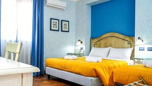 A hotel room with a bed, bedside tables, a chair, and a desk. - Vrbo Property (Pozzallo)