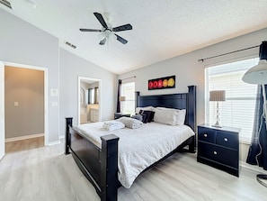 A bedroom with a bed, a nightstand, a lamp, a ceiling fan, and a window with blinds. - 4BR Villa Near Disney w/ Game Room & Private Pool (Kissimmee)