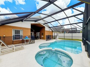 Ein überdachter Poolbereich im Freien mit Terrasse, Sitzgelegenheiten und einem umzäunten Spielbereich.