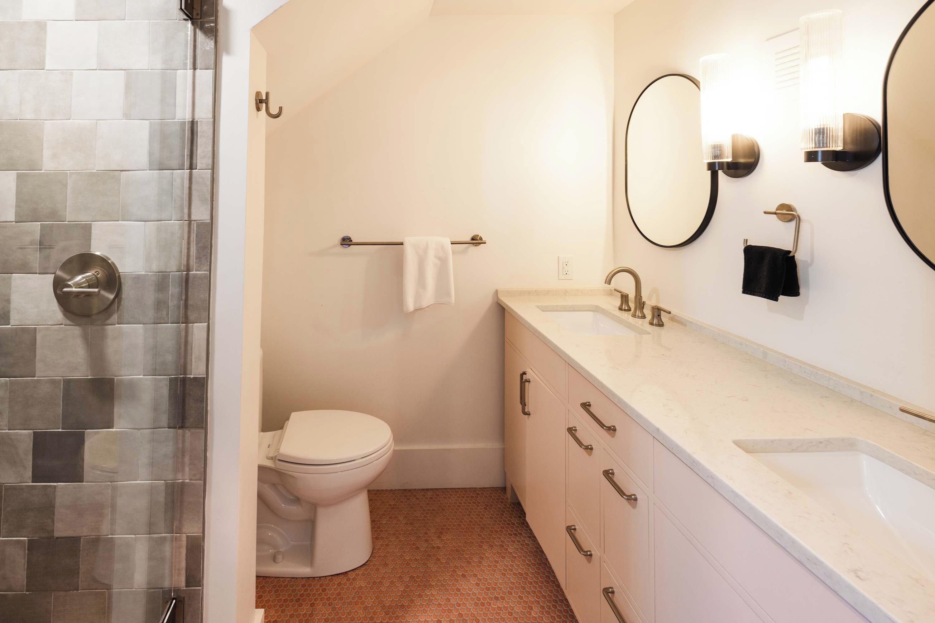 A bathroom with a toilet, sink, and mirror.